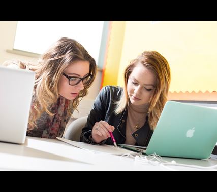 Two Students Working At A Laptop