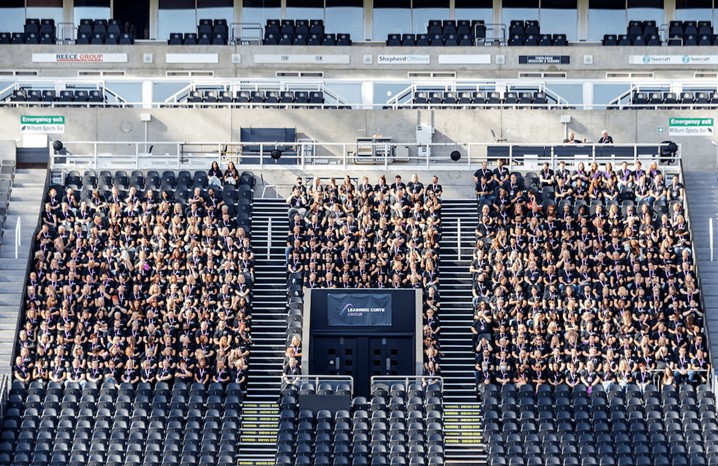 Learning Curve Group staff in a stadium