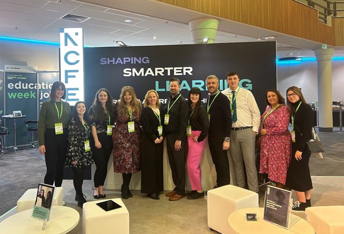 A group of colleagues standing in front of a conference stand