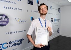 A learner holds up a certificate
