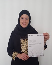 Female learner holds up certificate